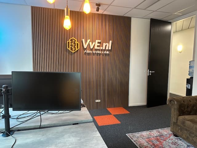 Het kantoor van VvE.nl met het logo op een houten lamellenwand